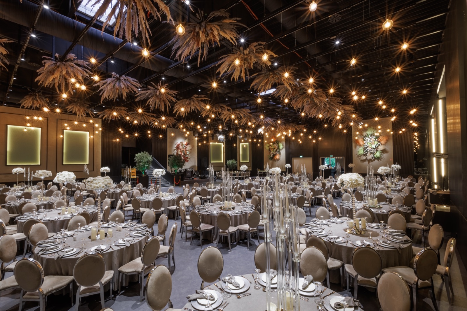 Saal Antea — Premium-Bankettsaal mit Pampas-Lichtinstallation und gold gerahmten Wänden